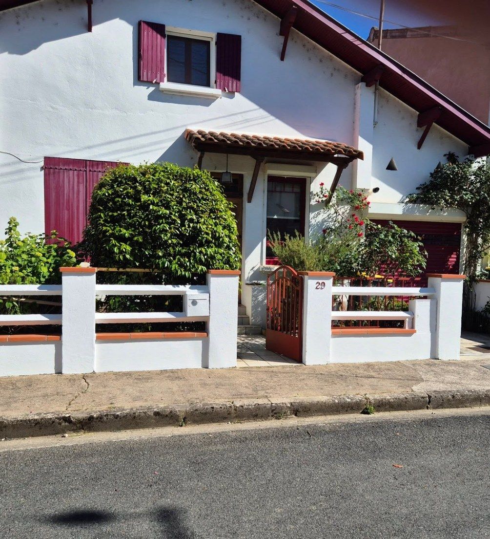 Façade de maison repeinte avec volets bordeaux